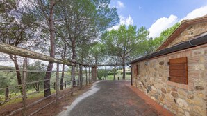 A stone building with a wooden door and a metal fence. - Holiday Home 'I Mandrioli' with Private Terrace, Wi-Fi and Air Conditioning (Casale Marittimo)