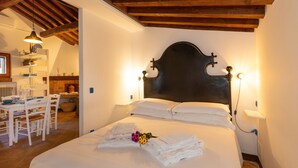 A bedroom with a wooden ceiling, a bed with white linens, a bedside table, and a lamp. - Holiday Home 'I Mandrioli' with Private Terrace, Wi-Fi and Air Conditioning (Casale Marittimo)