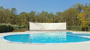 A swimming pool with a modern architectural structure in the background, surrounded by lush greenery. - Shalban Green Resort (Gazipur)