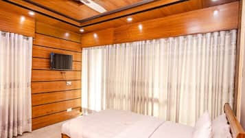 A bedroom with a wooden ceiling, a bed with a wooden headboard, and curtains.