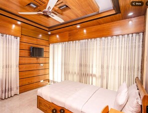 A bedroom with a wooden ceiling, a bed with a wooden headboard, and curtains. - Shalban Green Resort (Gazipur)