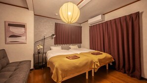 A hotel room with a double bed, a bedside table with a lamp, a sofa, and a large window with curtains. - Closest whole house from Haneda Airport (Higashikojiya, Ota-ku)