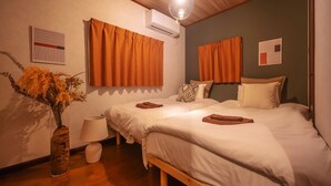 A bedroom with two beds, a wooden ceiling, an air conditioner, and a vase with dried flowers. - Closest whole house from Haneda Airport (Higashikojiya, Ota-ku)