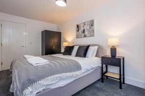 A bedroom with a bed, bedside tables, a wardrobe, and a painting on the wall. - Toast Stays - The Slate at Parsons House (Washington)