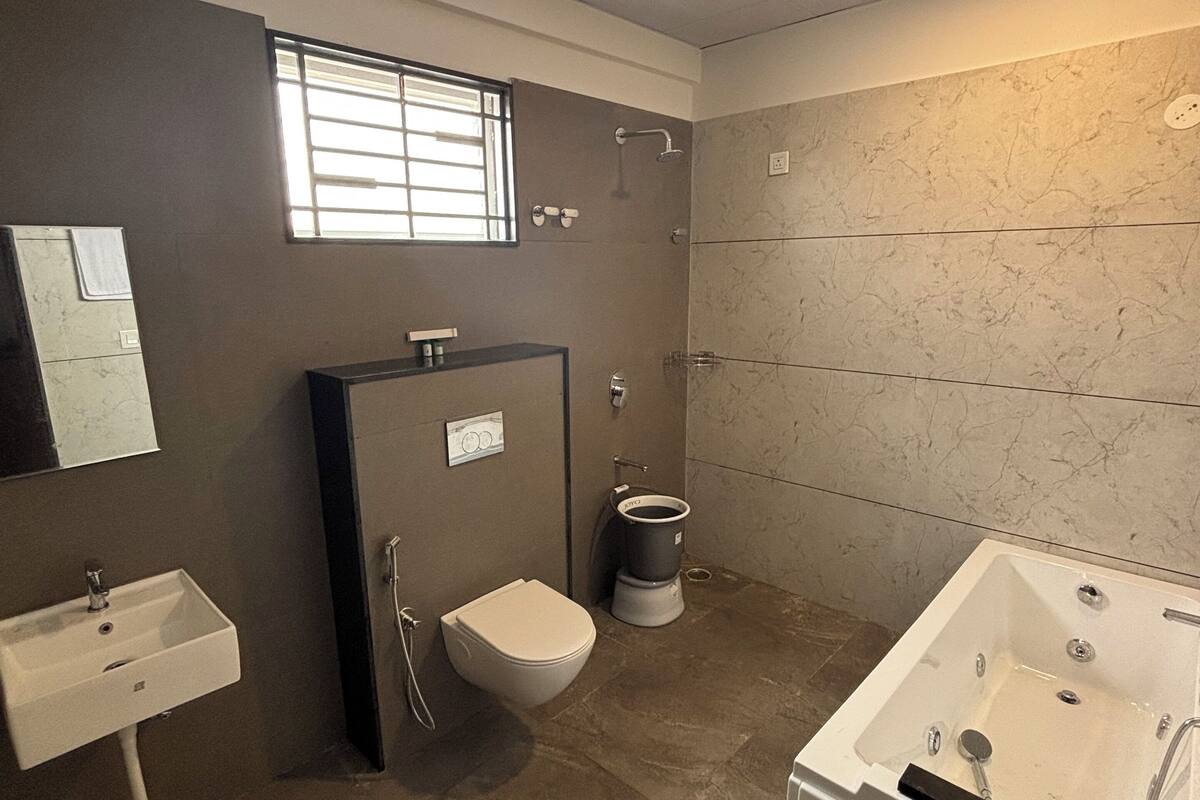 A modern bathroom with a bathtub, toilet, sink, and shower.