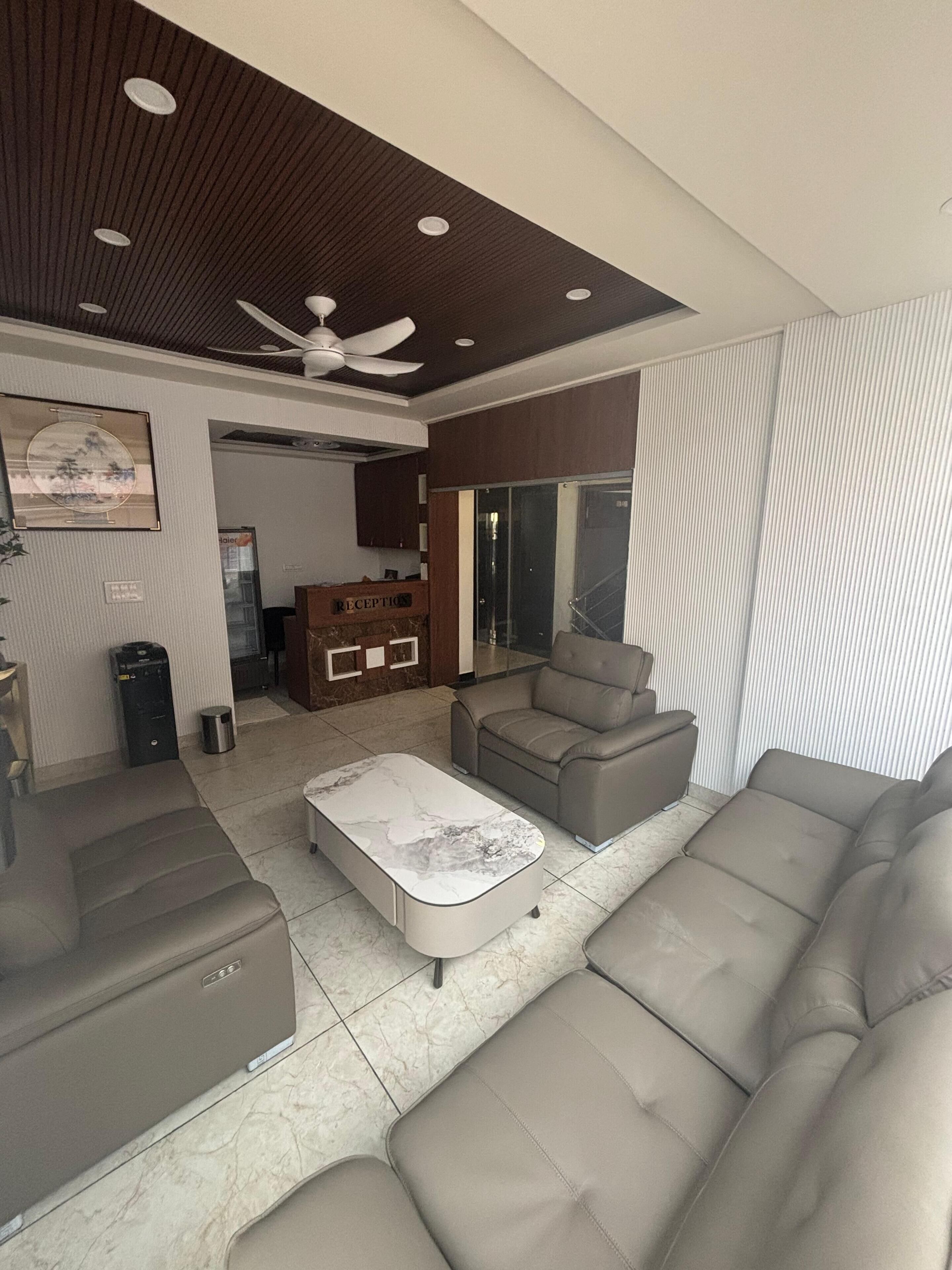 A modern living room with a sofa, a coffee table, and a reception desk.
