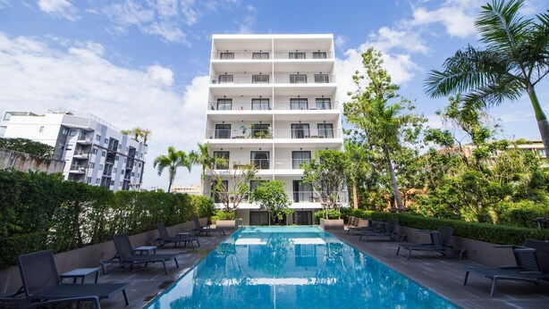 A modern building with a pool and lounge chairs. - Palm Bay Studio T3 -532 (Chalong)