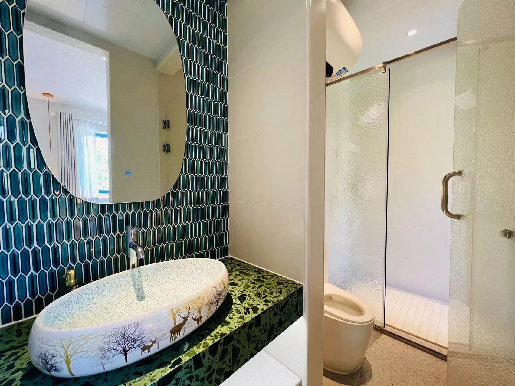A bathroom with a round sink, a mirror, and a shower area.