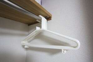 A white plastic hanger mounted on a wall.