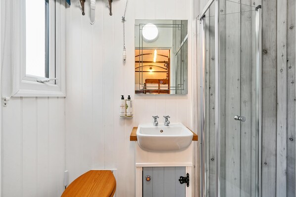 Une salle de bain avec un lavabo blanc, un meuble en bois et un miroir.
