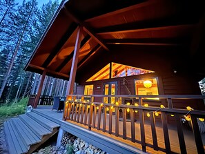 A wooden cabin with a deck, a covered porch, and a view of the forest. - Chalet Zen By Saimaa Hills (Miettilä)