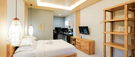 A modern bedroom with a wooden bed, bedside table, and a TV on a wooden stand.