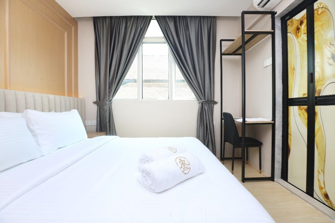 Une chambre d’hôtel avec un lit, un bureau et une chaise.