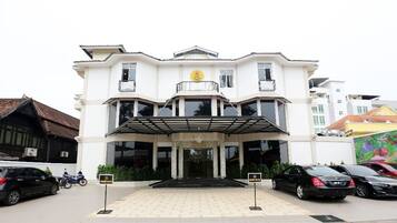 A two-story building with a central entrance, a covered walkway, and a sign indicating it is the Royal Guest House.