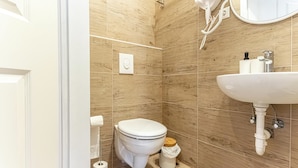 A bathroom with a toilet, a sink, and a mirror. - Chic 1BR Apt Walk to Vienna Sights (Vienna)