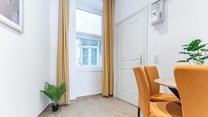 A room with a window, a door, a potted plant, and a table with chairs. - Chic 1BR Apt Walk to Vienna Sights (Vienna)