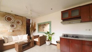 A modern living room with a sofa, coffee table, and a potted plant.