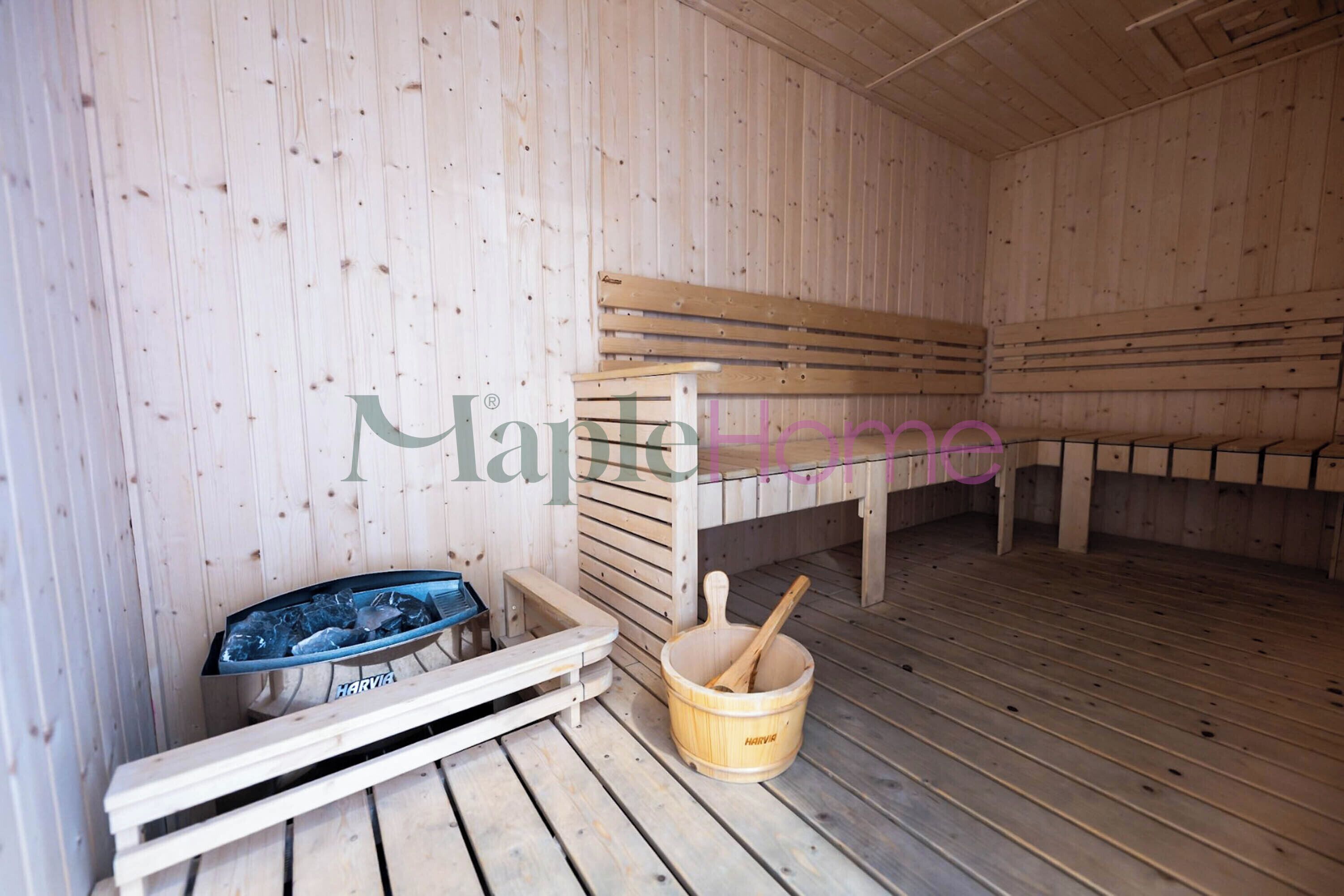A sauna room with wooden benches, a bench seat, a basin with ice, and a wooden bucket.