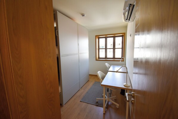 A compact kitchen with a window, a dining table, and a built-in oven. - Lindo Vale 412 (Porto)