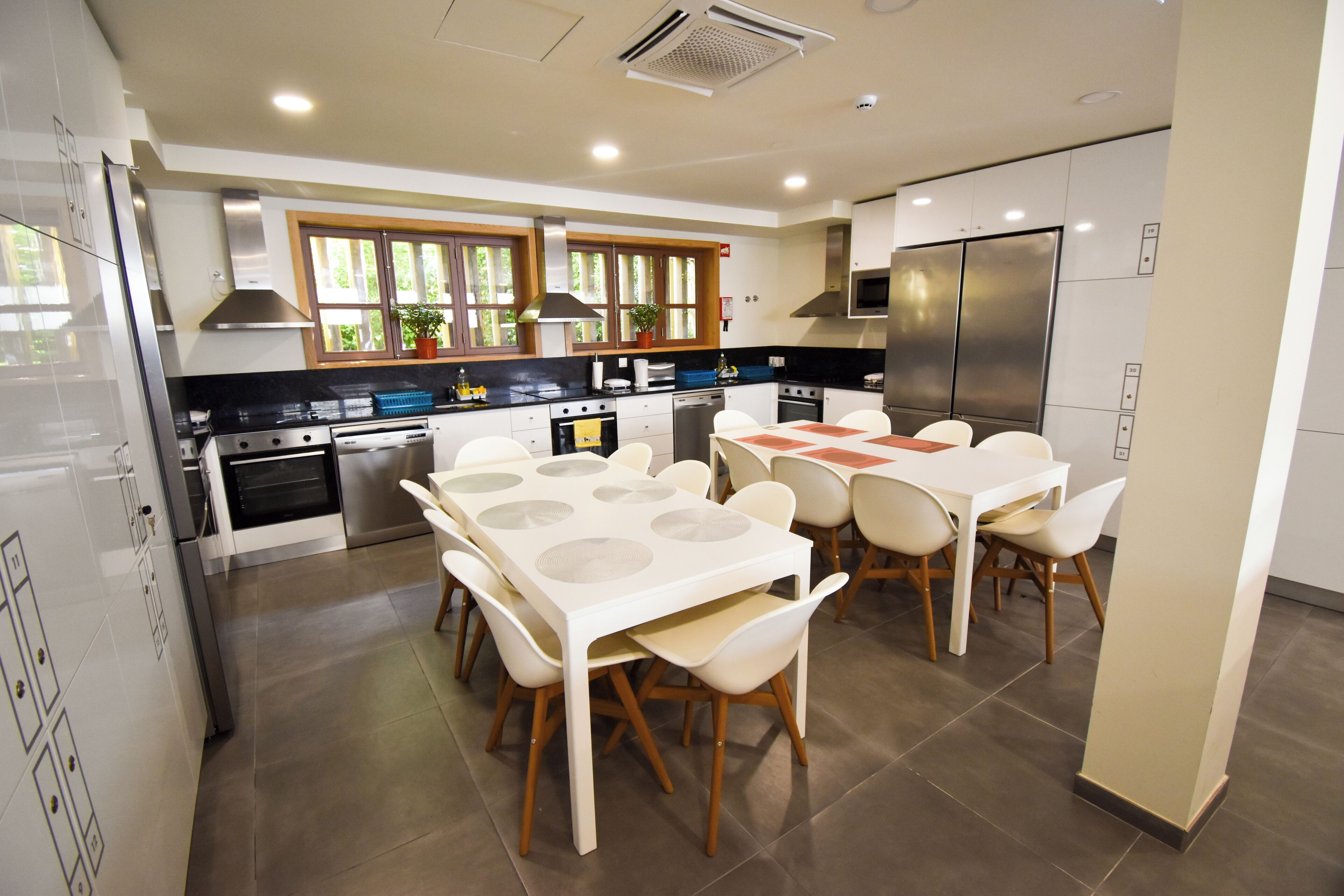 A modern kitchen with a dining area, featuring a large island, built-in appliances, and ample natural light.