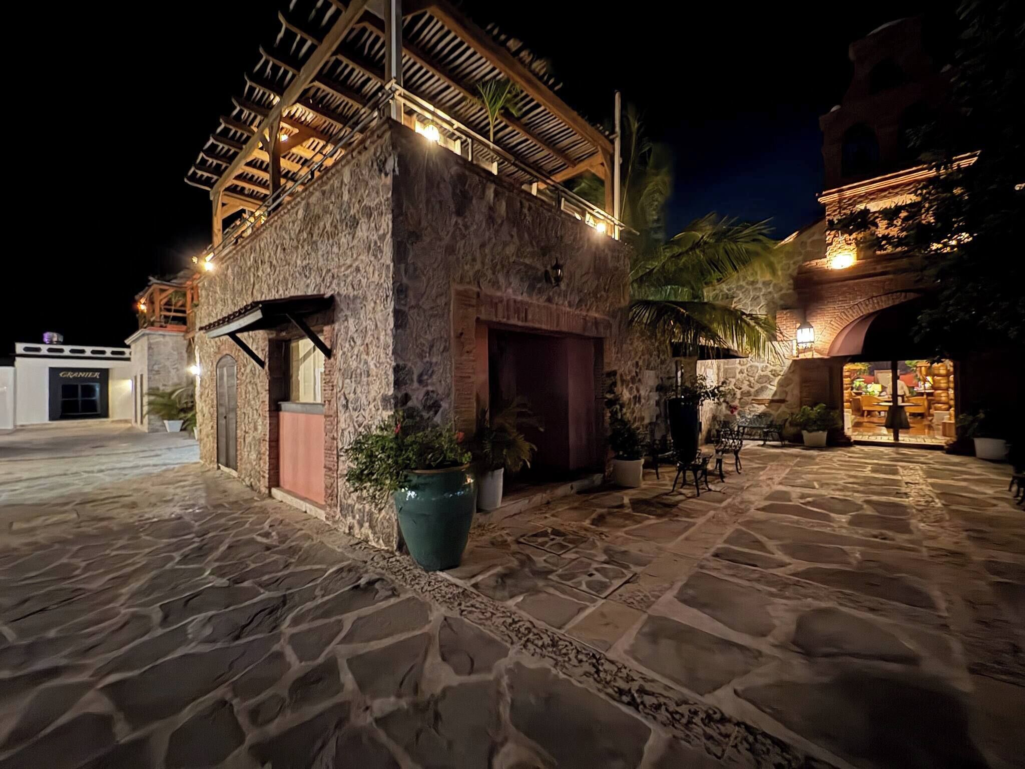Un edificio in pietra con patio coperto, posti a sedere all'aperto e un ingresso di un ristorante ben visibile.