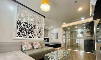 A modern living room with a sofa, decorative wall art, and a glass coffee table.