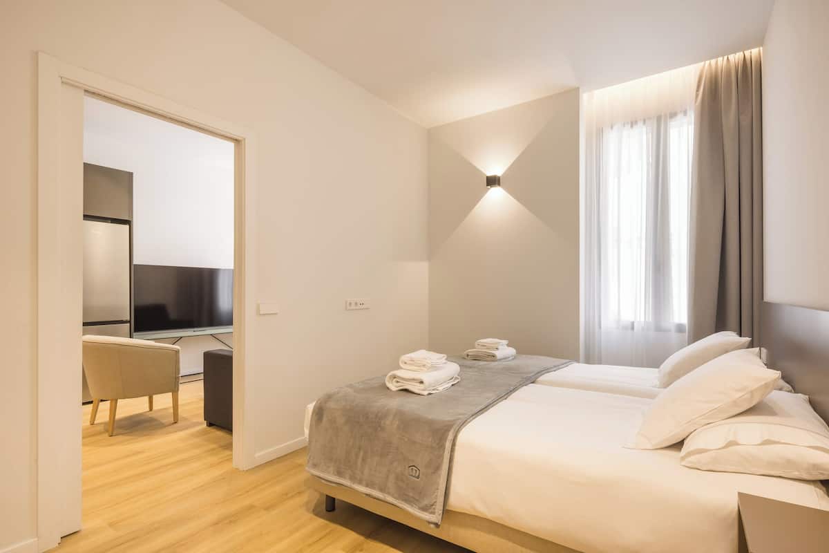 Una habitación de hotel moderna con una cama, un escritorio y un televisor.