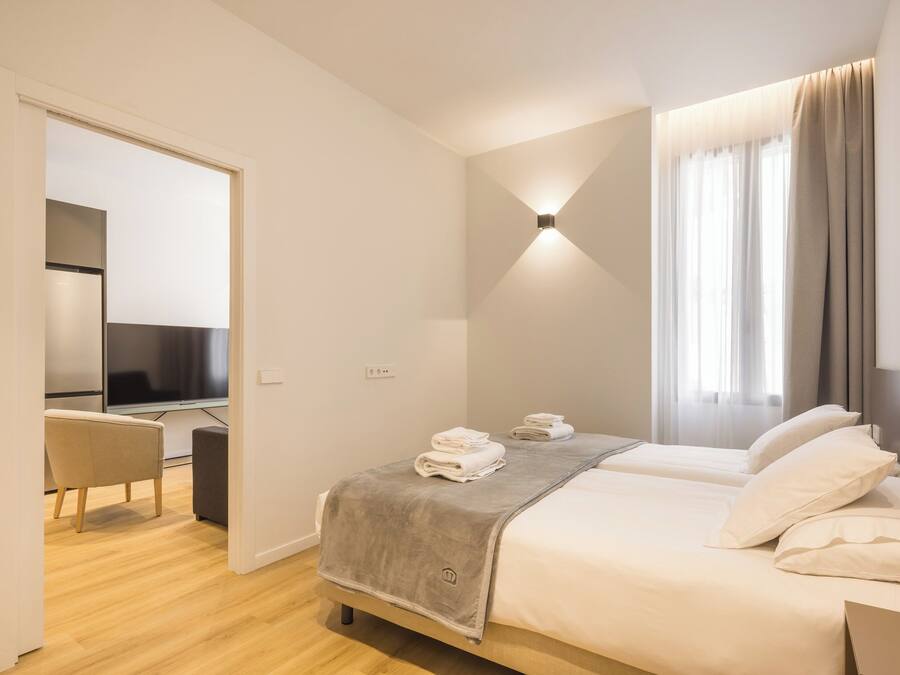 Ein modernes Hotelzimmer mit einem Bett, einem Schreibtisch und einem Fernseher.