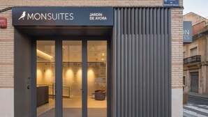 A modern building with a sign reading "MONSUITES" and "JARDÍN DE AYORA". - Mon Suites Jardín de Ayora (València)