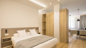 Un dormitorio moderno con una cama grande, un armario de madera y una zona de escritorio.