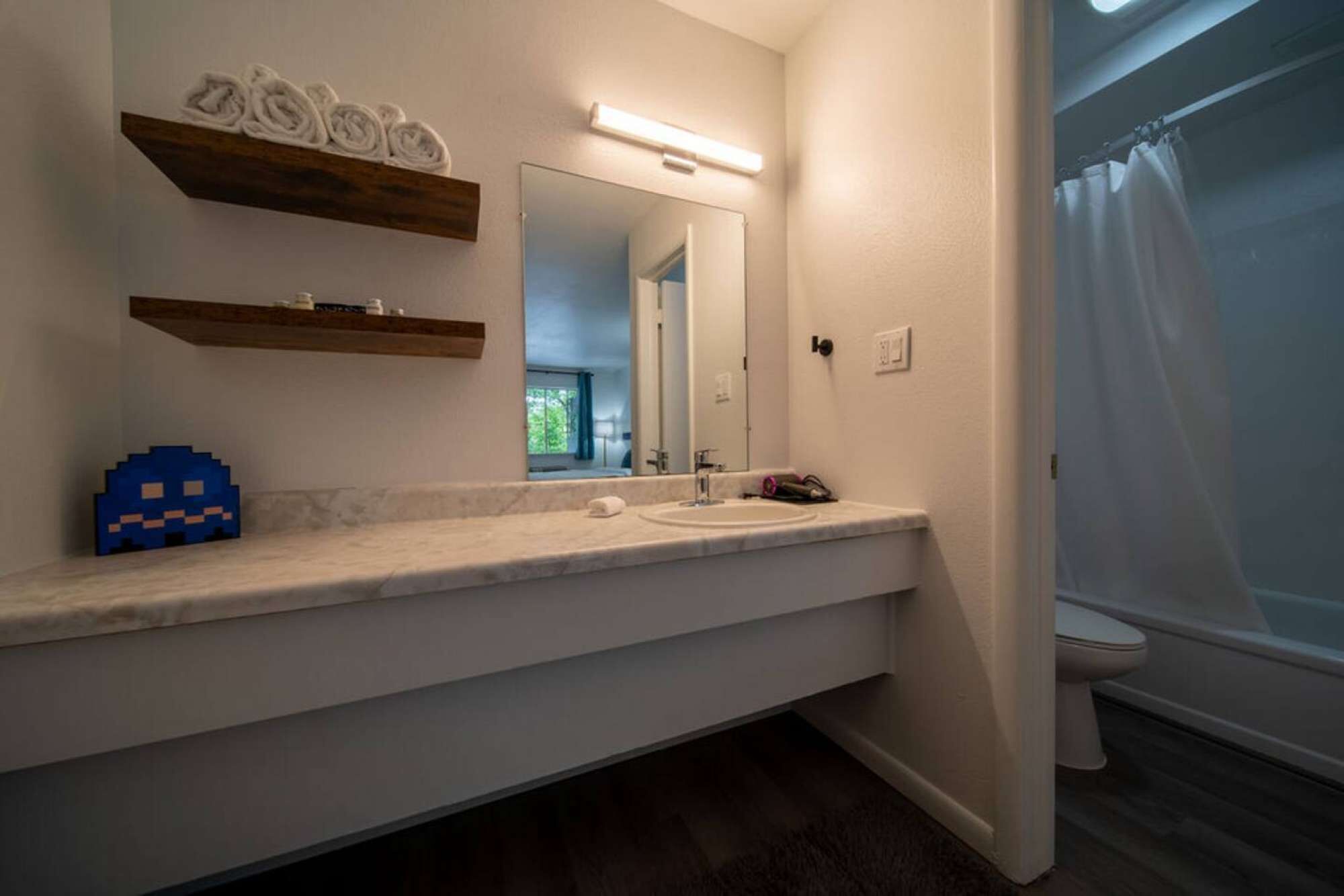 A bathroom with a white sink, mirror, and towel rack.