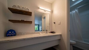 A bathroom with a white sink, mirror, and towel rack.