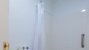 A bathroom with a toilet, a shower with a curtain, a bathtub, and a handrail. - KC Room, #7 at Glory Dayz! (Eureka Springs)