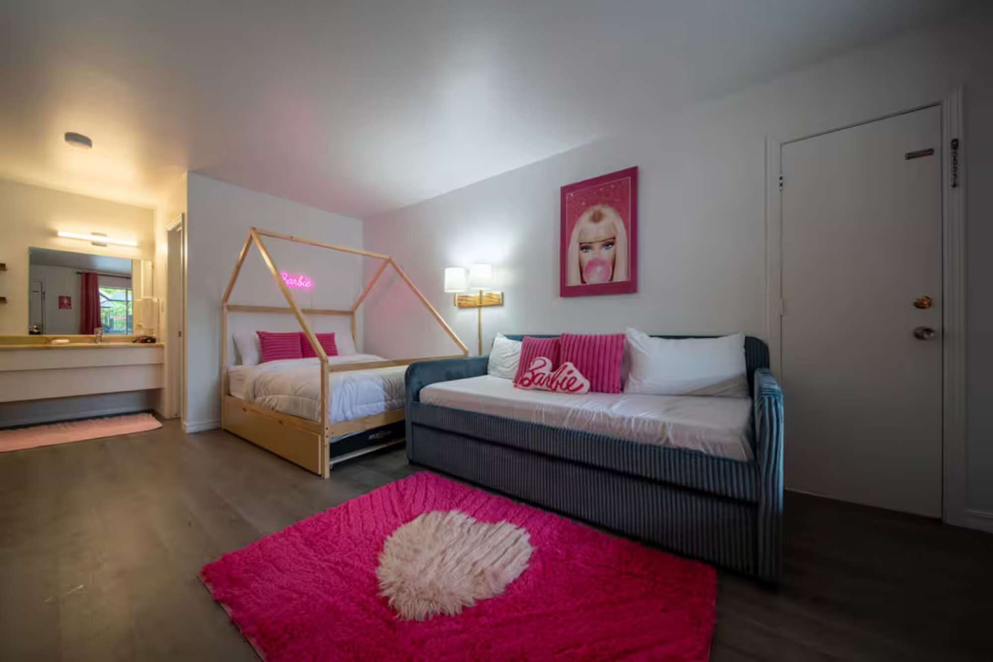 Un dormitorio con cama, sofá, espejo y puerta.