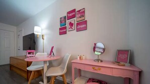 A bedroom with a bed, a desk with a mirror, a chair, a dresser, and a vanity table. - Pink Room, #16 at Glory Dayz! (Eureka Springs)