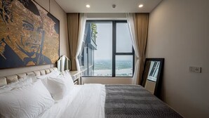 Habitación de hotel con una cama grande, vistas a un paisaje urbano y un cuadro abstracto de gran tamaño en la pared.