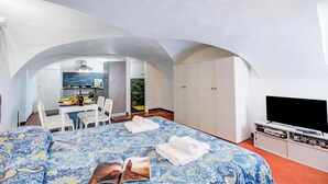 A hotel room with a bed, a television, a desk with a chair, and a wardrobe. - Casa Vacanze Maimone 3 Central Sanremo Old Town (Sanremo)