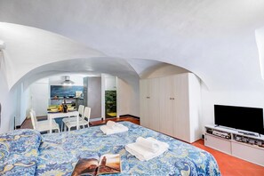 A hotel room with a bed, a television, a desk with a chair, and a wardrobe. - Casa Vacanze Maimone 3 Central Sanremo Old Town (Sanremo)
