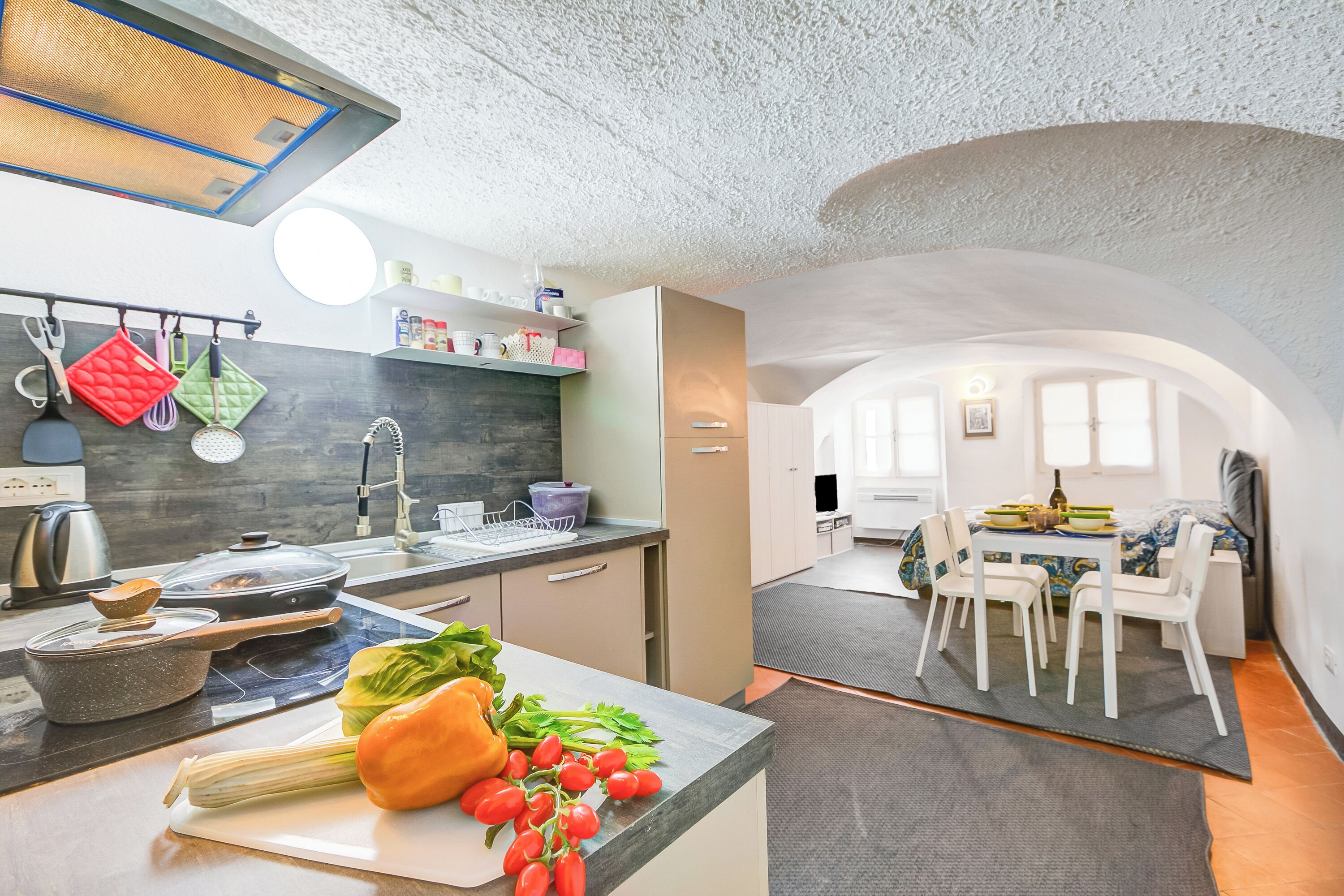 A modern kitchen with a dining area, featuring a kitchen island, a dining table with chairs, and a view of the dining area.