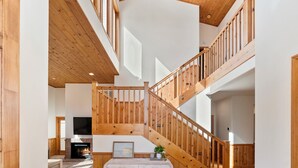 Un intérieur spacieux avec un escalier en bois, une cheminée et un coin repas.