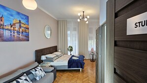 Ein modernes Schlafzimmer mit Bett, Nachttisch, Lampe, Gemälde und einem Schild mit der Aufschrift 'STUDIO A'.