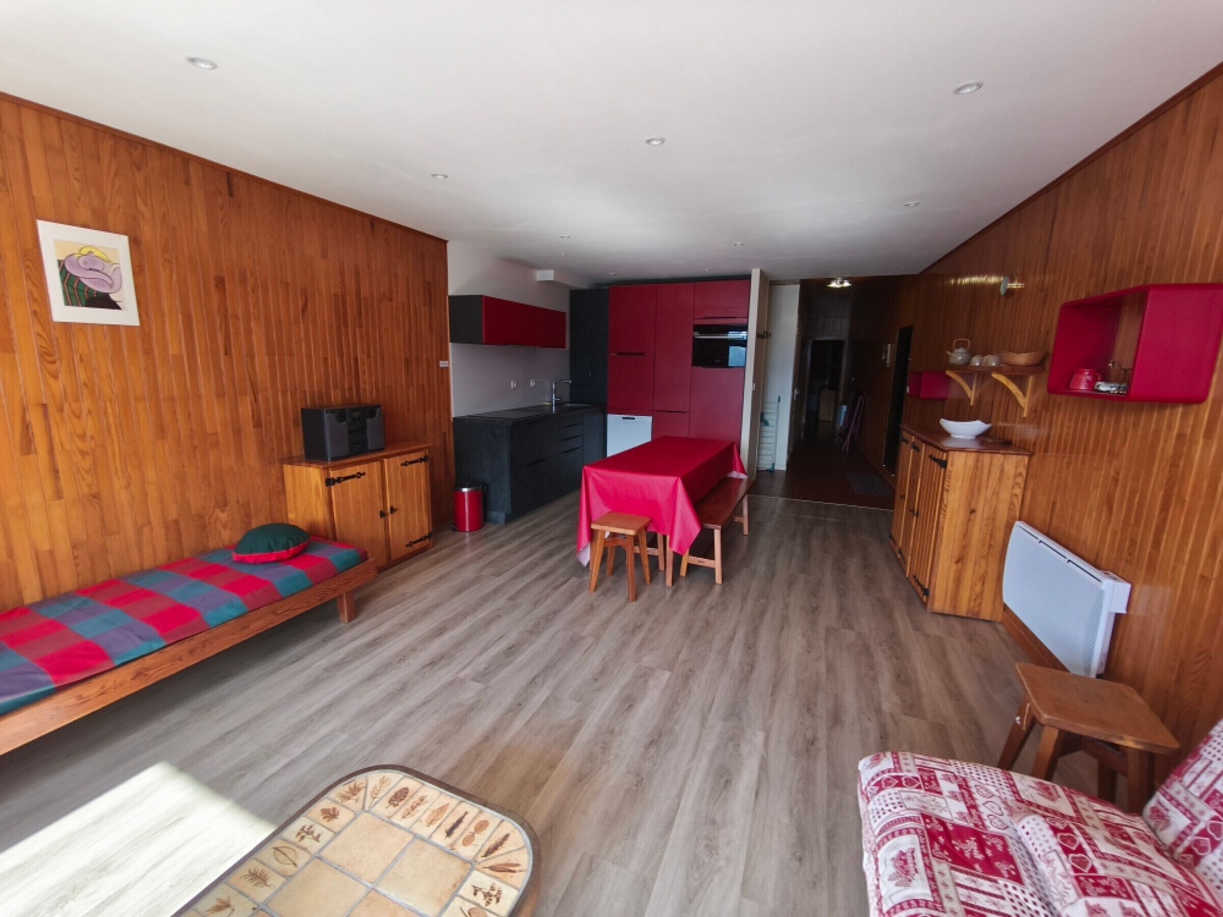 A compact living space with a kitchenette, a dining area, and a sofa.