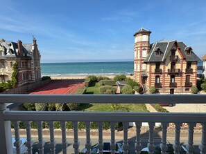 Une vue sur la côte, avec un court de tennis, une tour et un bâtiment doté d’un balcon.