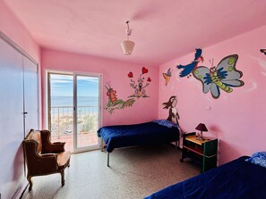 Une chambre rose avec deux lits, une chaise, un bureau et une fenêtre donnant sur un paysage agréable.