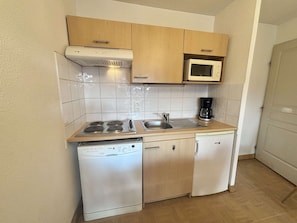 A compact kitchen with a stove, sink, microwave, and dishwasher. - 3-room apartment in Flumet for 6 with balcony, parking and pool (Flumet)