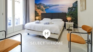 Ein Schlafzimmer mit einem Bett, zwei Nachttischen und zwei Stühlen.