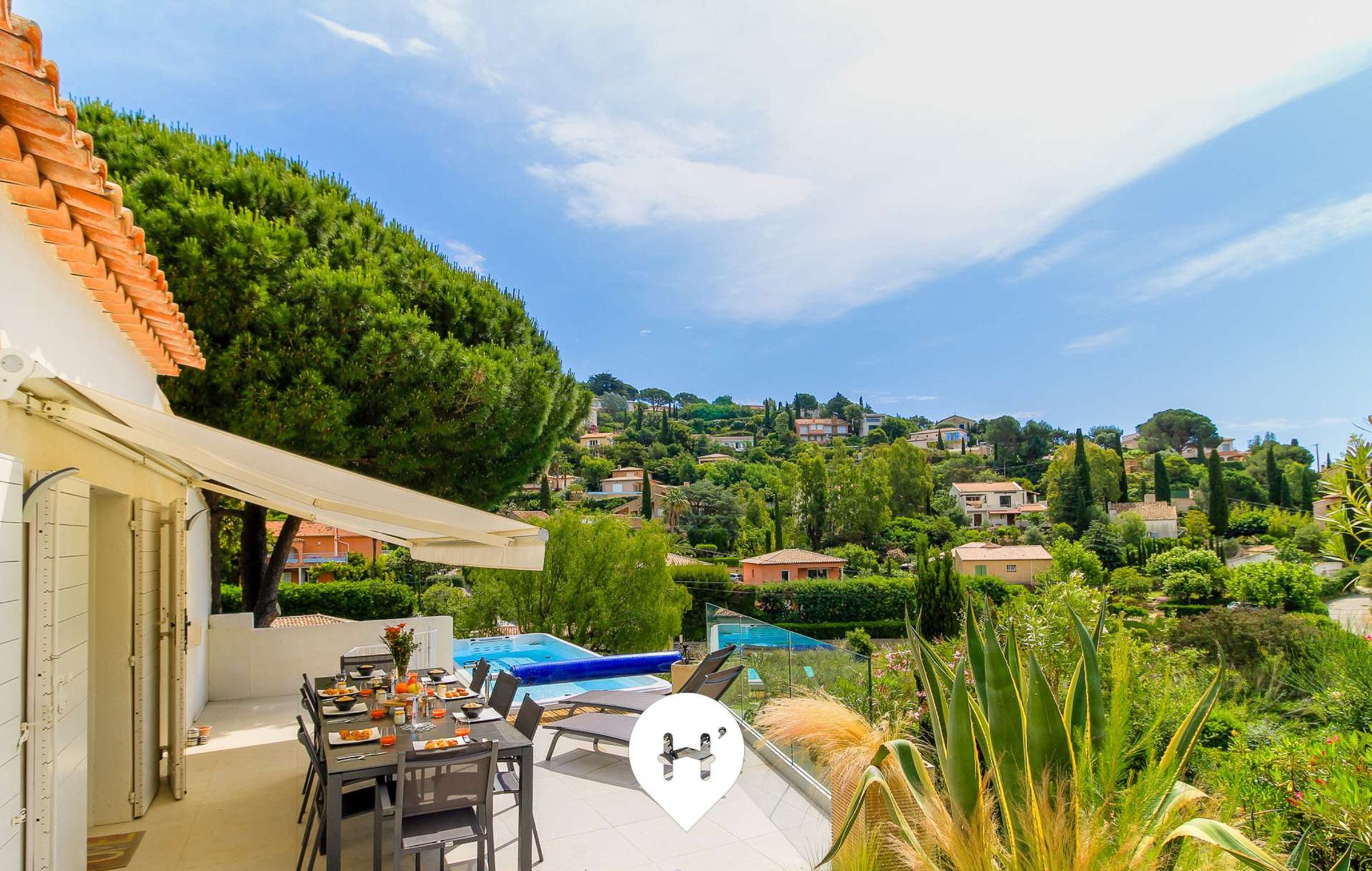 Um terraço com mesa de jantar, cadeiras e piscina.