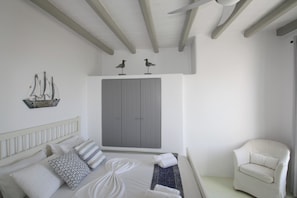 A bedroom with a bed, a chair, a wardrobe, and decorative items on the wall.