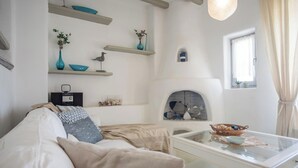 Una sala moderna con sofá, mesa de centro y objetos decorativos en estanterías.