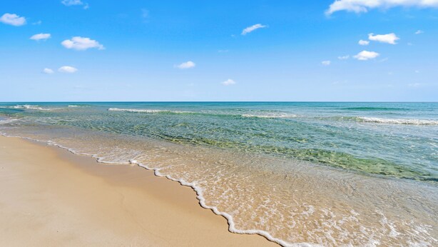 A beach with clear blue water and a sandy shore. - "Forever Summer" | Dog Friendly | Pensacola Beach | My Beach Getaways (Pensacola Beach)